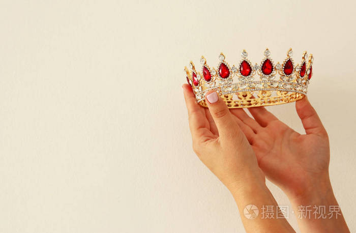 女子手捧皇冠以示胜利或赢得第一名白色背景复制空间孤立