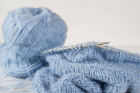 蓝色针织羊毛纱和针织针。不完全针织项目