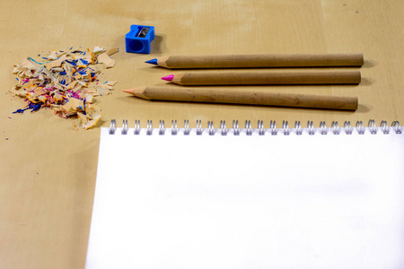蜡笔和铅笔刀木制办公桌子上。蜡笔 w