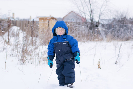 快乐的男孩在雪地里漫步