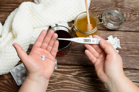 治疗流感和感冒。在木桌上的热茶蜂蜜和药品