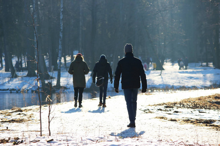 冬天, 三人在公园里一起散步, 对抗阳光。