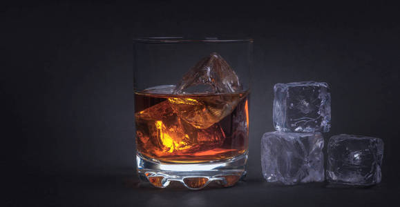威士忌加冰块在深色背景上