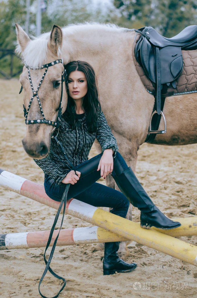 美丽的褐发骑士摆着马, 在乡间牧场骑马.骑马生活照片时尚照片