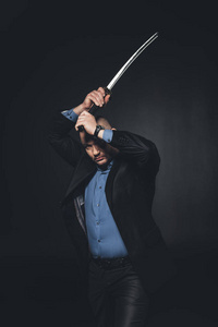 成熟的人在西装打黑武士刀剑照片