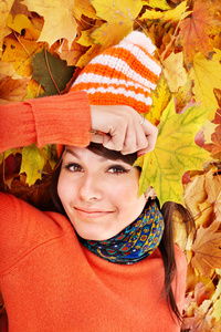 秋天橙色叶子的女孩。