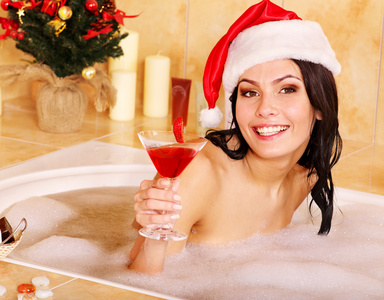 戴圣诞帽的女人在洗澡时放松。