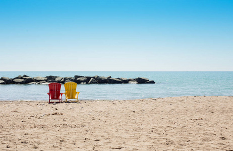 与两个多彩阿迪朗达克椅子的海滩场景
