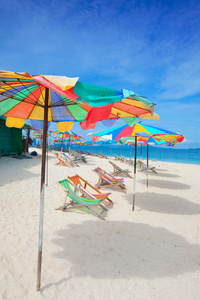 五颜六色的太阳伞，美丽的白沙上的太阳椅