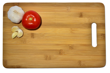 大蒜和番茄在切割板上隔离在白色上