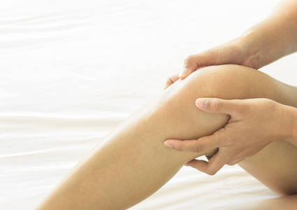 特写的女人手拿着膝关节疼痛床 卫生保健和医疗的概念
