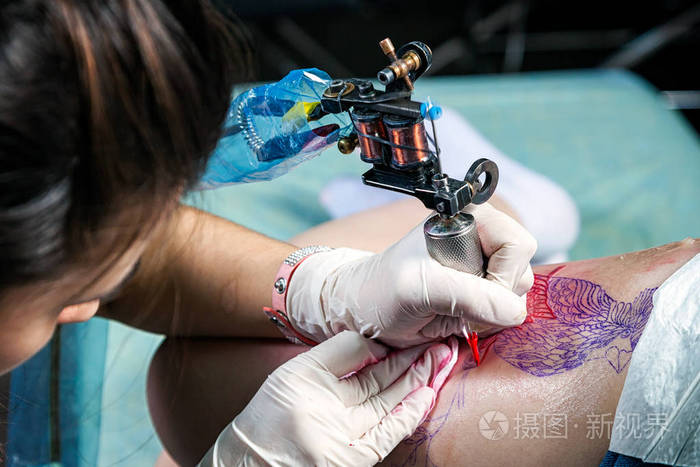 在无菌条件下, 由女性纹身大师在臀部上创建鸟纹身的过程