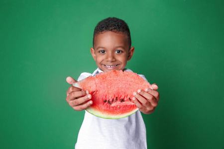 可爱的非洲裔美国人男孩吃西瓜在颜色背景