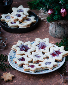 在盘子上, 杏仁饼干的形式与草莓果酱的明星。圣诞大餐