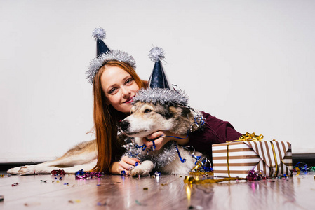 愉快的微笑 redhaired 女孩庆祝新的一年与她的狗, 许多箔