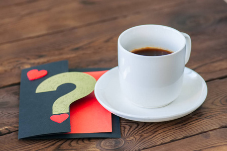 一杯黑咖啡和一张木制背景的卡片