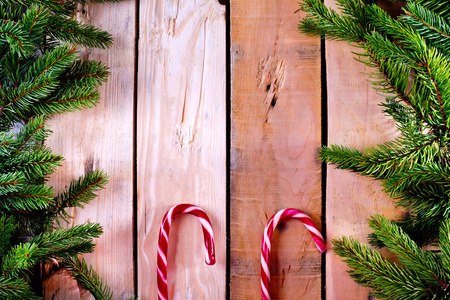 天然木质背景下的圣诞树框架与两个糖果