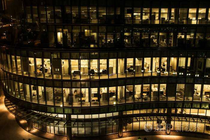 夜间在波士顿办公大楼的黄色灯光窗户玻璃幕墙办公大楼