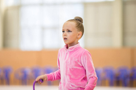 可爱的小女孩运动员训练，在艺术体操馆