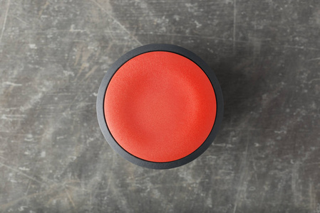 光滑混凝土中红色圆形按钮的顶部
