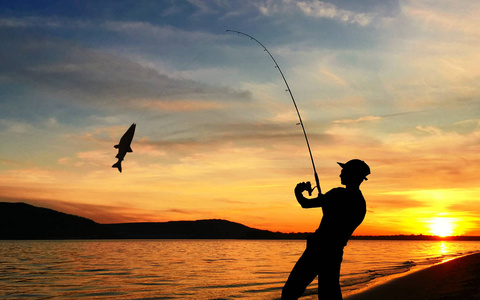 年轻人在日落钓鱼