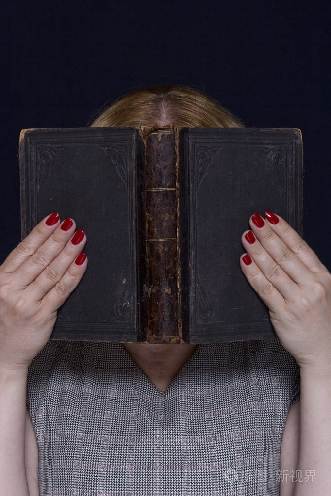 拿着一本书一个年轻女人的手