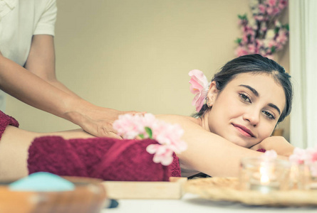 快乐的女人在温泉床上得到了背部按摩照片