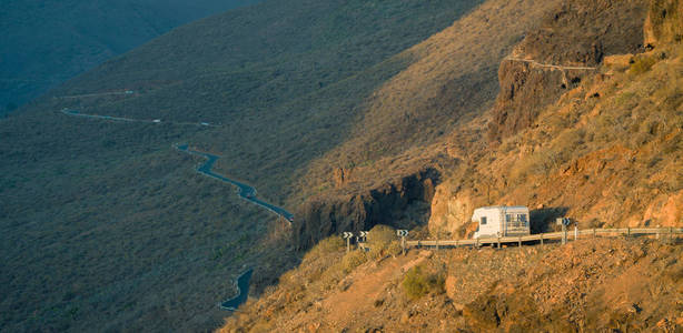 Campervan 在大加那利岛山区的曲线公路上骑马