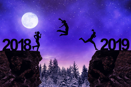 剪影女孩跳到新年2019在晚上照片
