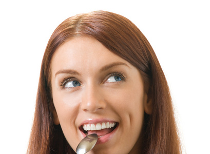 年轻微笑的女人的肖像，用勺子孤立在白色上