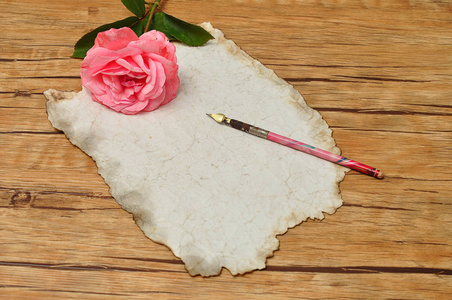 老式的钢笔与旧纸和粉红色的玫瑰