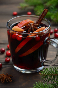 苹果和蔓越莓的圣诞热酒。用冷杉树枝蔓越莓和香料装饰的节日概念