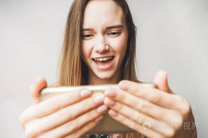 年轻女孩玩游戏在手机，上瘾，自拍照