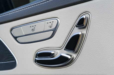 门把手与电源座位控制按钮的一辆豪华客车。白色真皮内饰的豪华现代车。现代汽车内部的细节