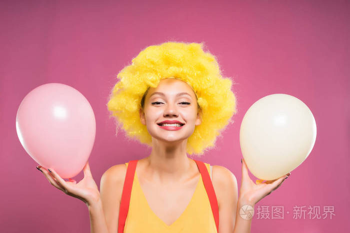 黄色头发的愉快的女孩拿着空气气球