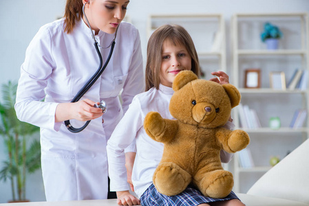 女医生检查小可爱的女孩与玩具熊