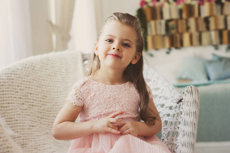 可爱 5 岁儿童小女孩微笑着坐在椅子上在家里的肖像
