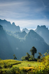 老挝坎斯特的山和蓝天。山前草地上的小家