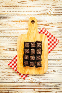 甜甜点与巧克力布朗尼蛋糕在木板切割板过滤器处理