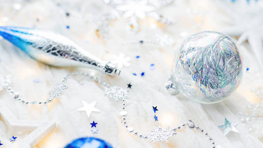 圣诞节和新年假期的背景装饰和灯泡。银色和蓝色发光的球, 雪花和星五彩纸屑