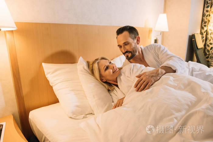 美丽的中年情侣浴袍醒来在酒店房间