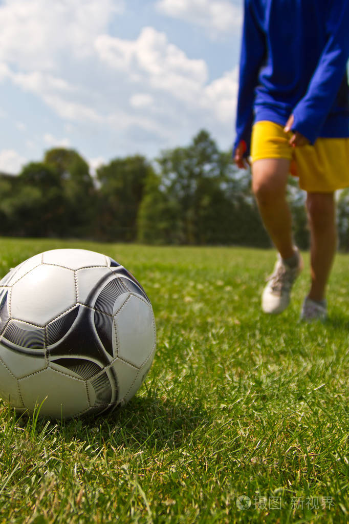 足球运动员踢起了皮球的腿