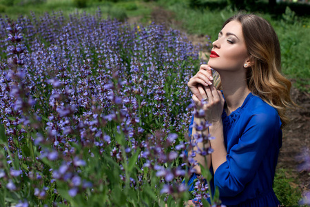 美女肖像化妆身穿蓝色连衣裙, 站在花卉花园, 绿色植物背景