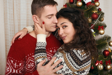 年轻夫妇与家庭室内圣诞树爱和假日概念, 圣诞前夕