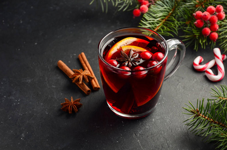 圣诞热葡萄酒与橙和蔓越莓。节日概念用冷杉树枝和香料装饰. 选择性聚焦