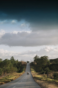 在天空多云的道路上的摩托车在背景下, 千里达, 古巴