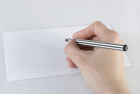 一只手握着笔在信封上写着白色的信
