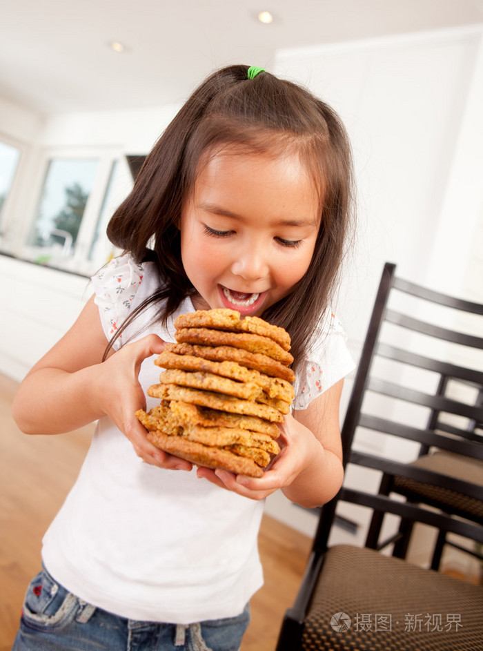 小女孩在吃一堆饼干
