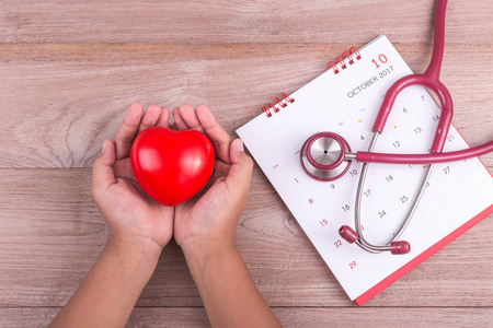 检查心脏概念 女人手里拿着红色的心和 stethosc