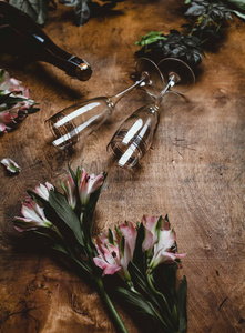 木桌上的鲜花香槟瓶和眼镜